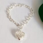 Pulsera de eslabones plateados con dije de corazón texturizado de acero inoxidable