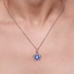 Collar con colgante de ojo turco con un marco de piedras brillantes en forma de flor.
